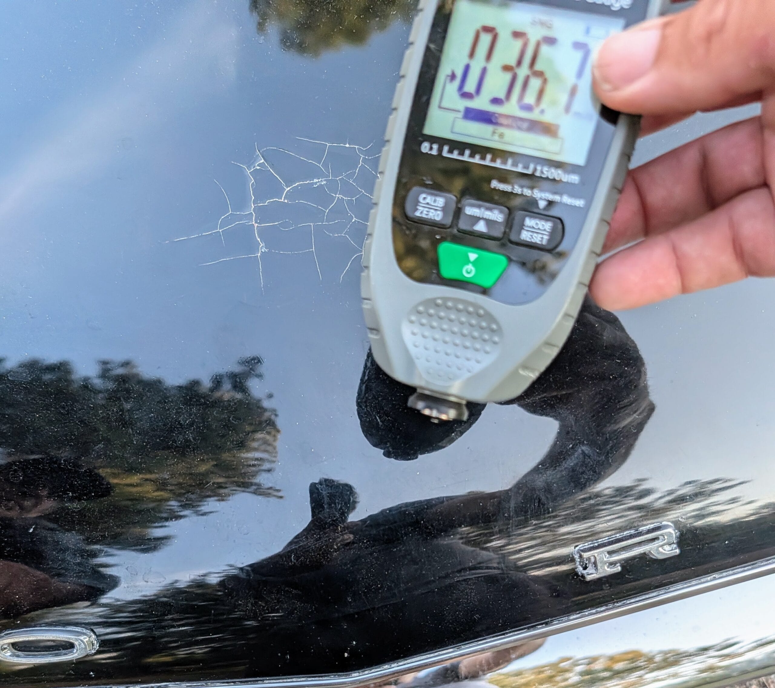 Close-up of paint and body telemetry measurement during vehicle inspection