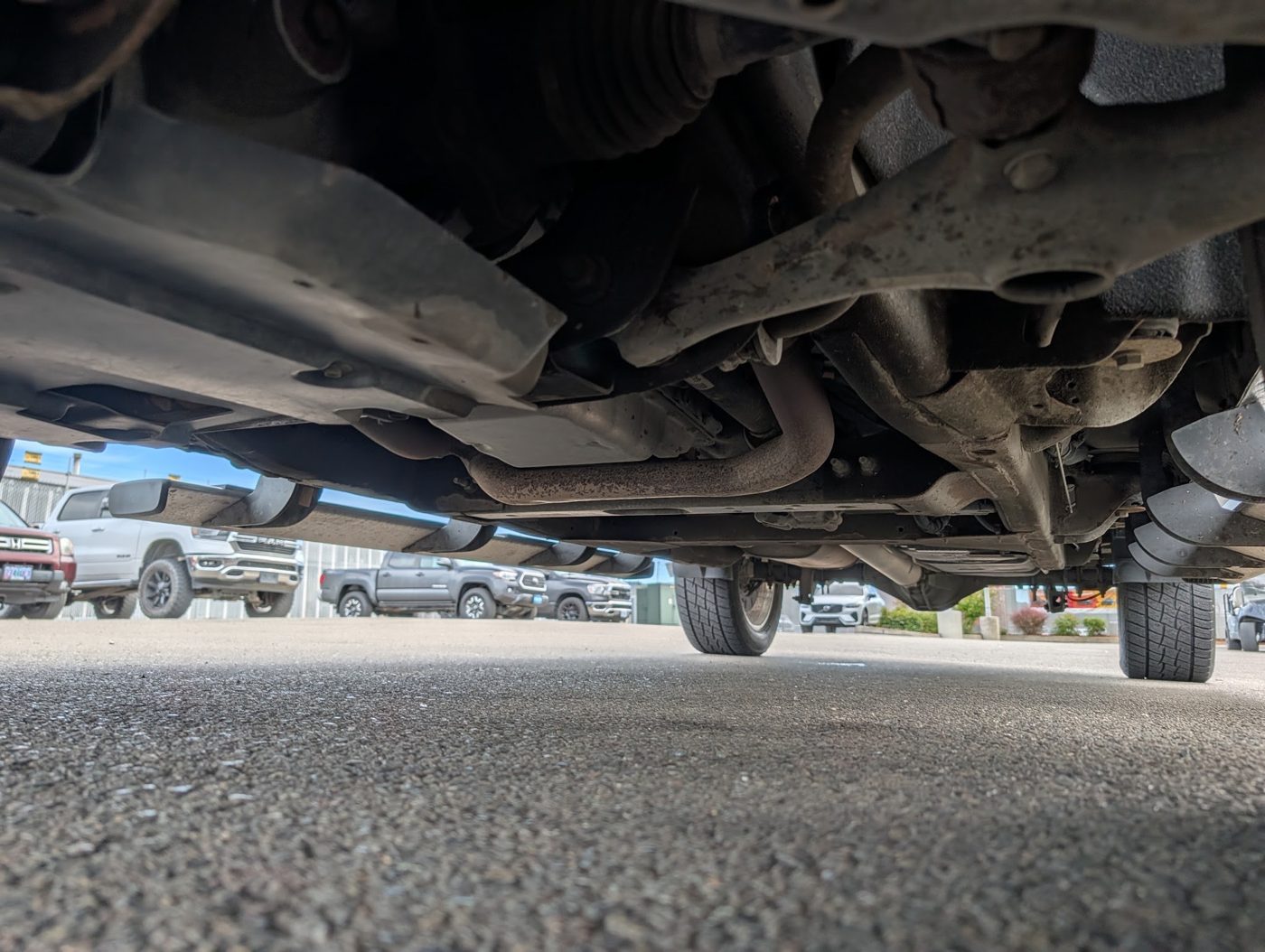 Pickup underbody and front suspension inspected from below for rust and damage