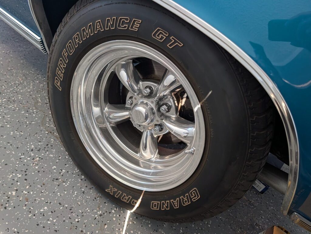 Tire and chrome wheel inspected for tread depth and wear during a pre-trip inspection